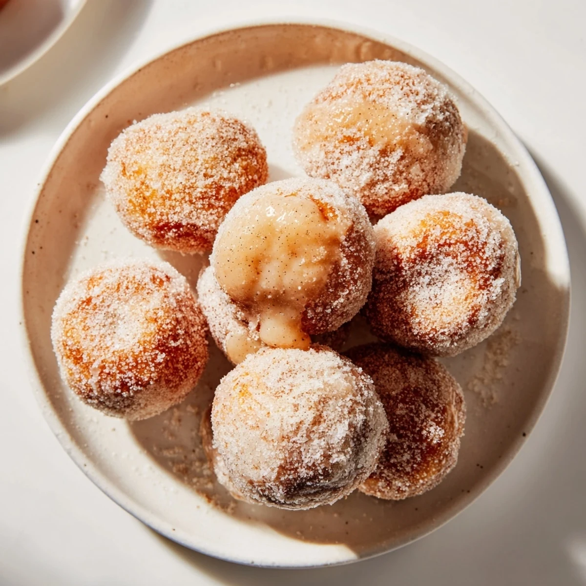 Golden-brown cinnamon sugar donut holes, fresh from the fryer, ready to be enjoyed with coffee.