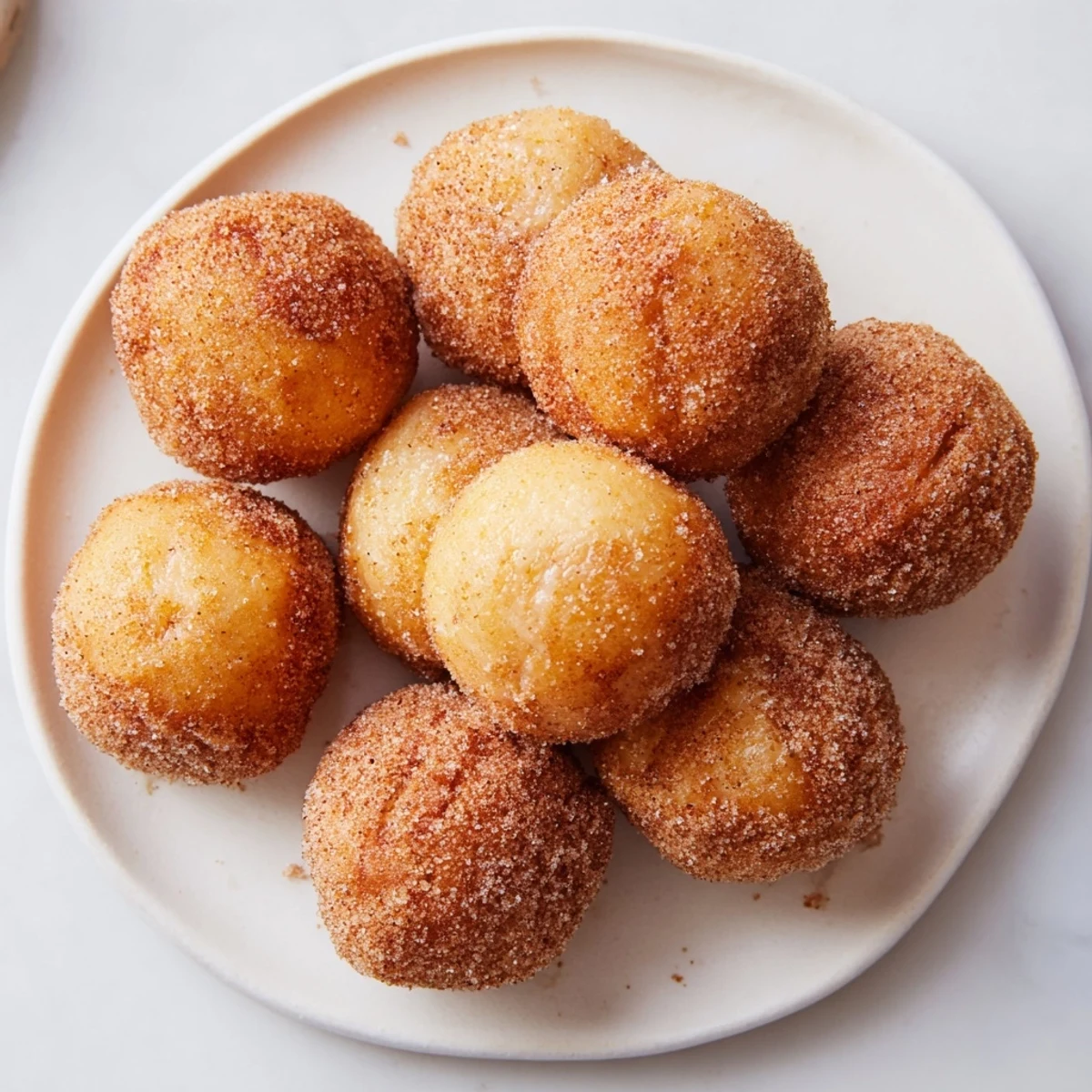 Picture fluffy, bite-sized cinnamon sugar donut holes glistening from a coating of sweetness.