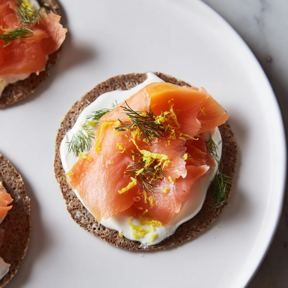 A stack of delightful Smoked Salmon and Cream Cheese Blinis, ready to enjoy with a glass of bubbly.