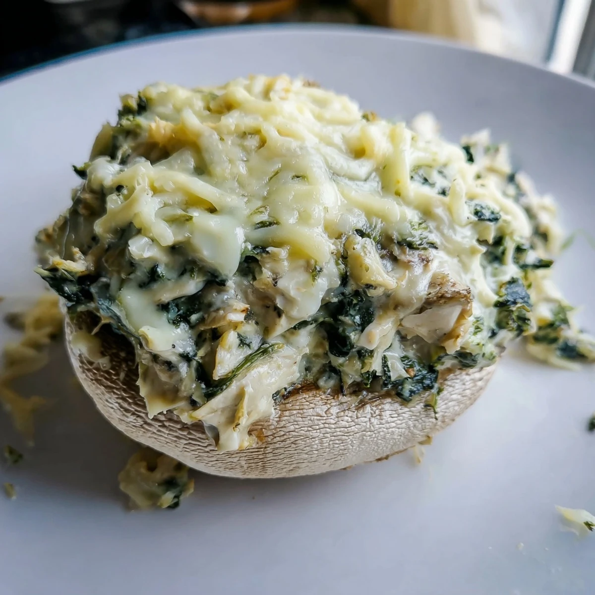 Golden-brown Cheesy Spinach Artichoke Stuffed Mushrooms boast a bubbly cheese topping, ideal appetizer.
