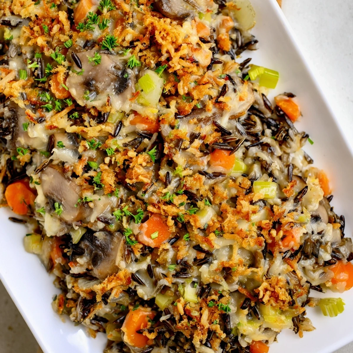 Steaming hot Creamy Mushroom and Wild Rice Casserole, bubbly and golden, a perfect vegetarian meal.