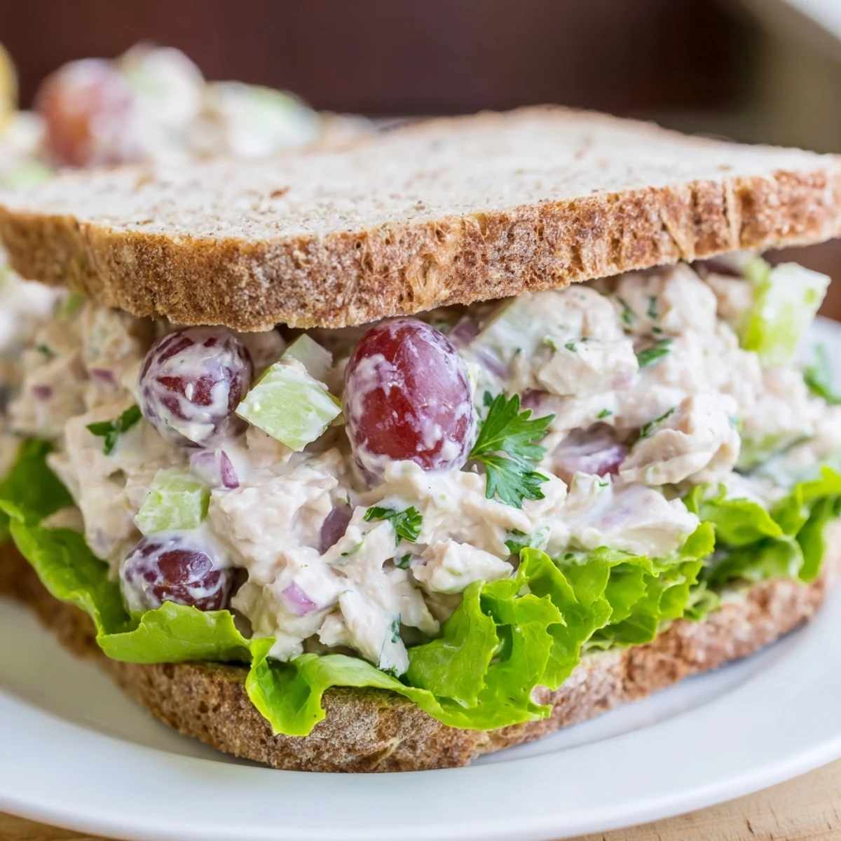 Close-up of a chicken salad sandwich with grapes, displaying a cool, refreshing summer meal idea.