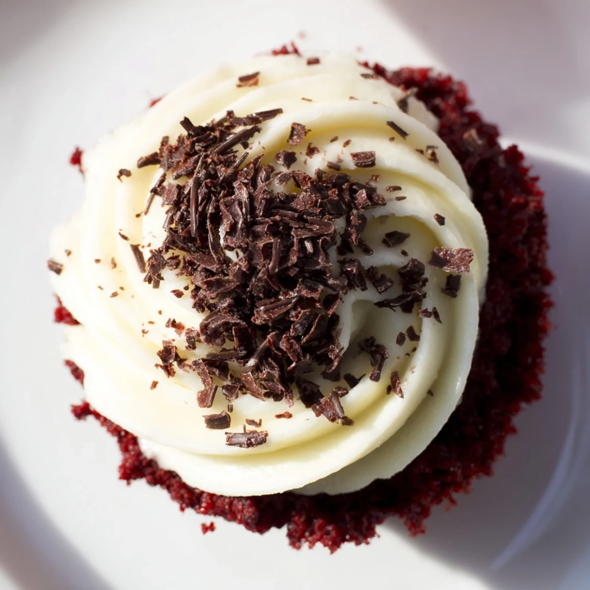 Moist, ruby-red Red Velvet Cupcakes with cream cheese frosting, served alongside a glass of cold milk for dipping.