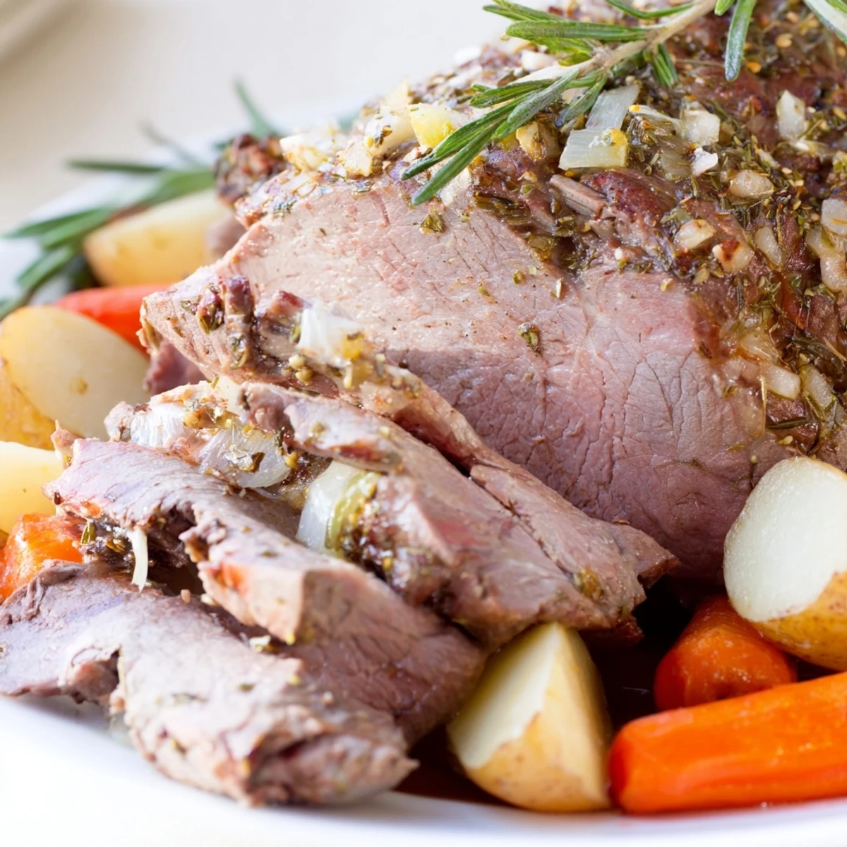 Golden brown leg of lamb roasted with garlic and lemon, resting before being sliced for dinner.