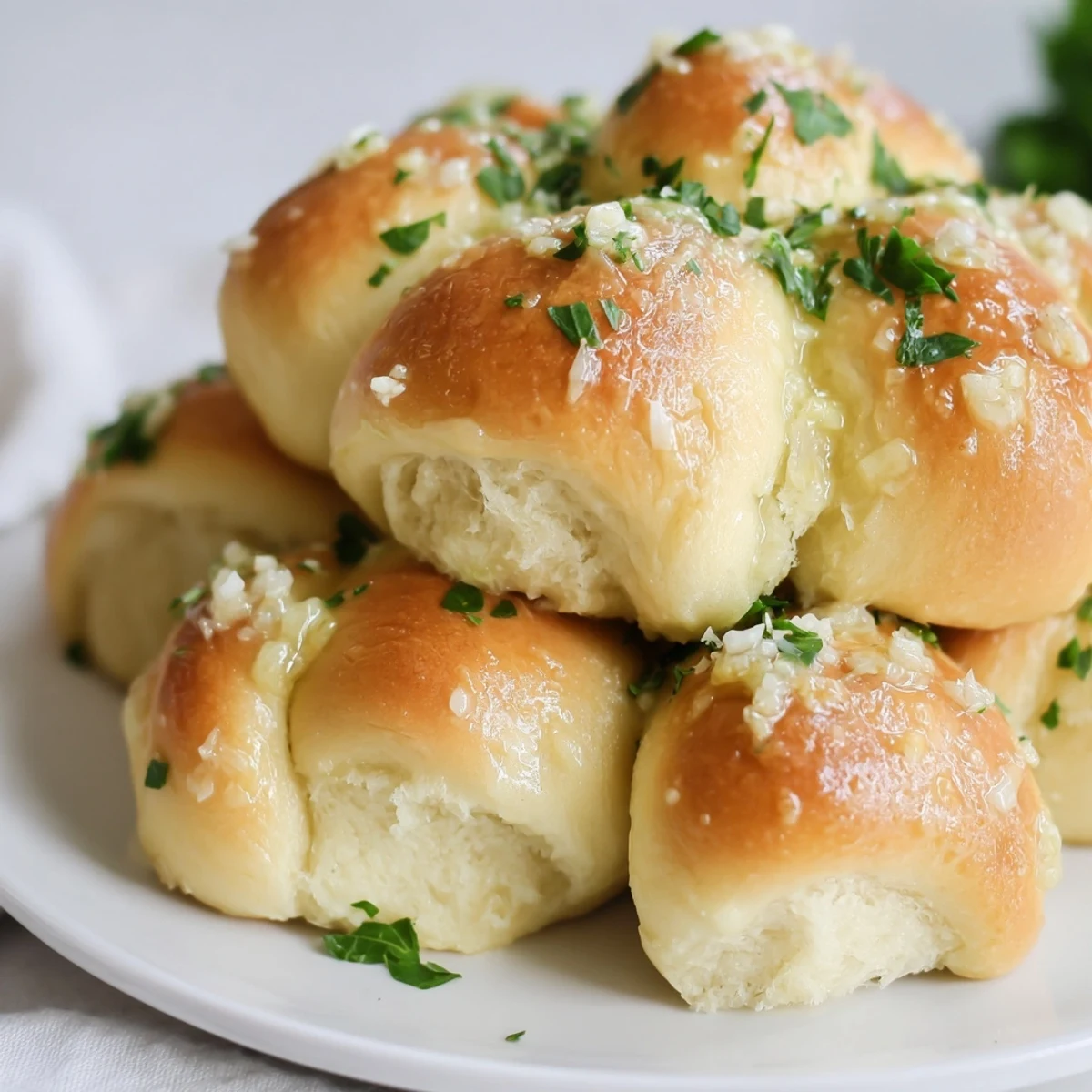 Twisted dough knots topped with grated Parmesan and herbs, fresh from the oven on a rustic tray for snacking.