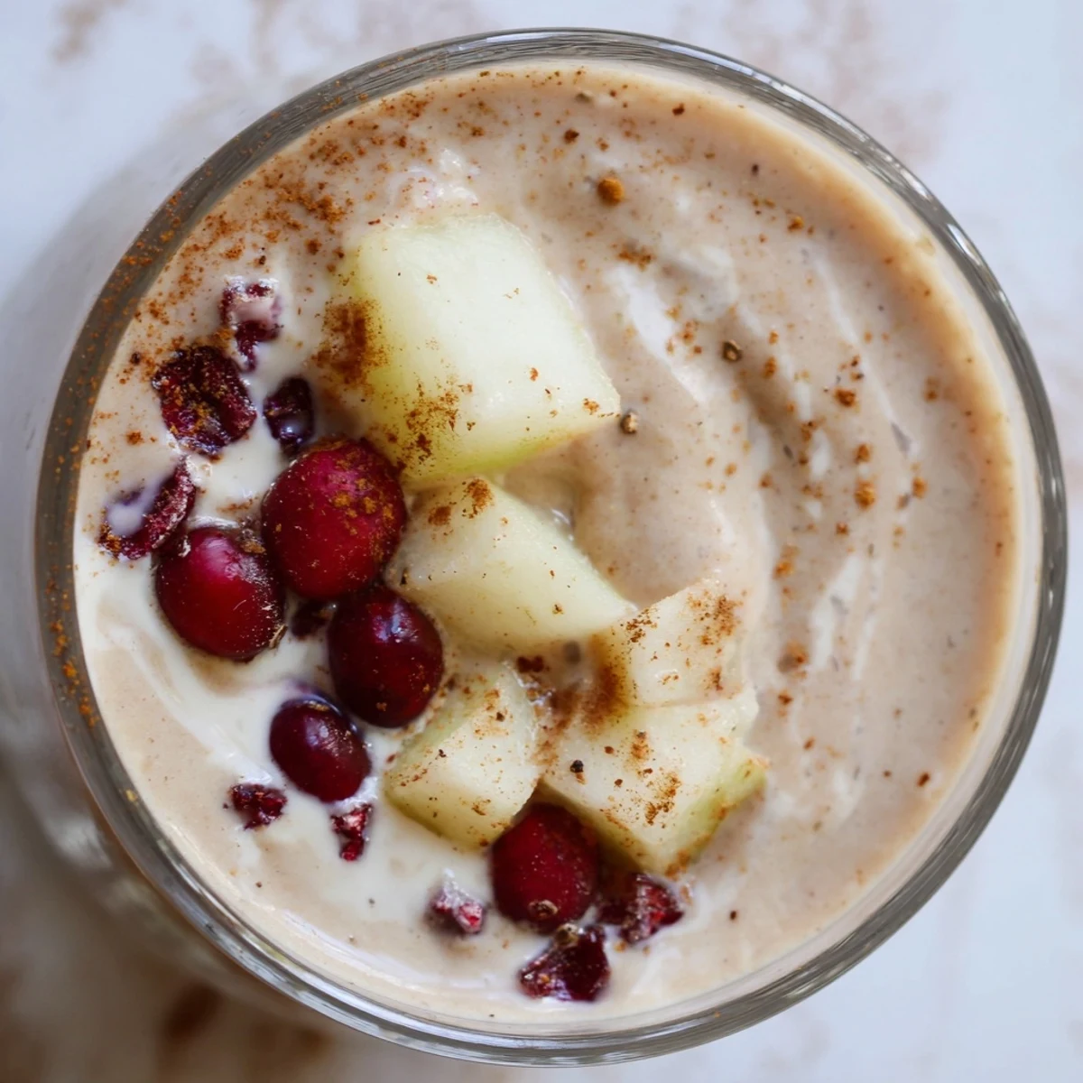 Creamy Winter Smoothie Blend with almond milk and Greek yogurt, garnished with a cinnamon stick and fresh pear slices.
