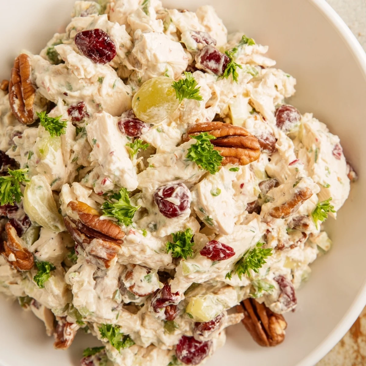 Bright bowl of Chicken Salad with Pecans and Cranberries, garnished with fresh parsley, ideal for meal prep or a light dinner.