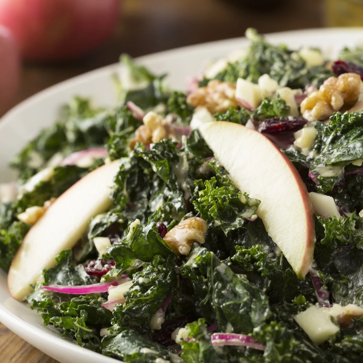Bright green winter kale salad with apple and cheddar, tossed with tangy maple-Dijon vinaigrette and garnished with crunchy toasted pecans.
