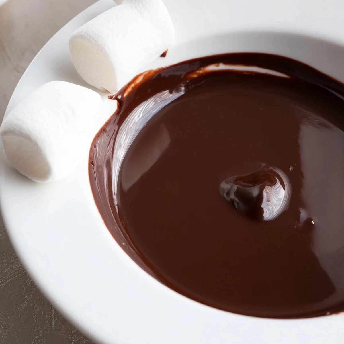 Molten Romantic Chocolate Fondue with Marshmallows paired with fruit and brioche cubes, lit by a tea light for date night.