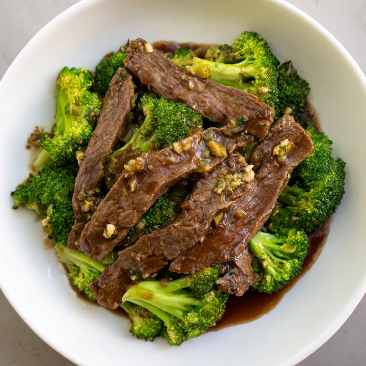 Steaming stir-fry of tender beef and vibrant green broccoli florets coated in a glossy soy sauce glaze, served over white rice.
