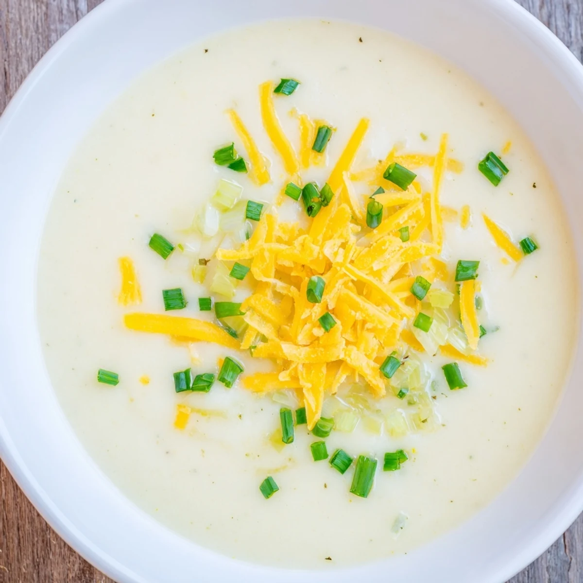 Creamy Irish Potato Leek Soup with Sharp Cheddar served in a rustic mug with crusty bread.