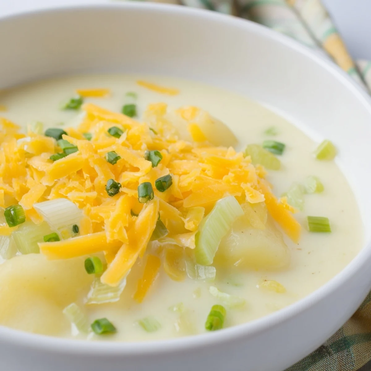 Silky blended Irish Potato Leek Soup with Sharp Cheddar topped with melted cheese and chives.