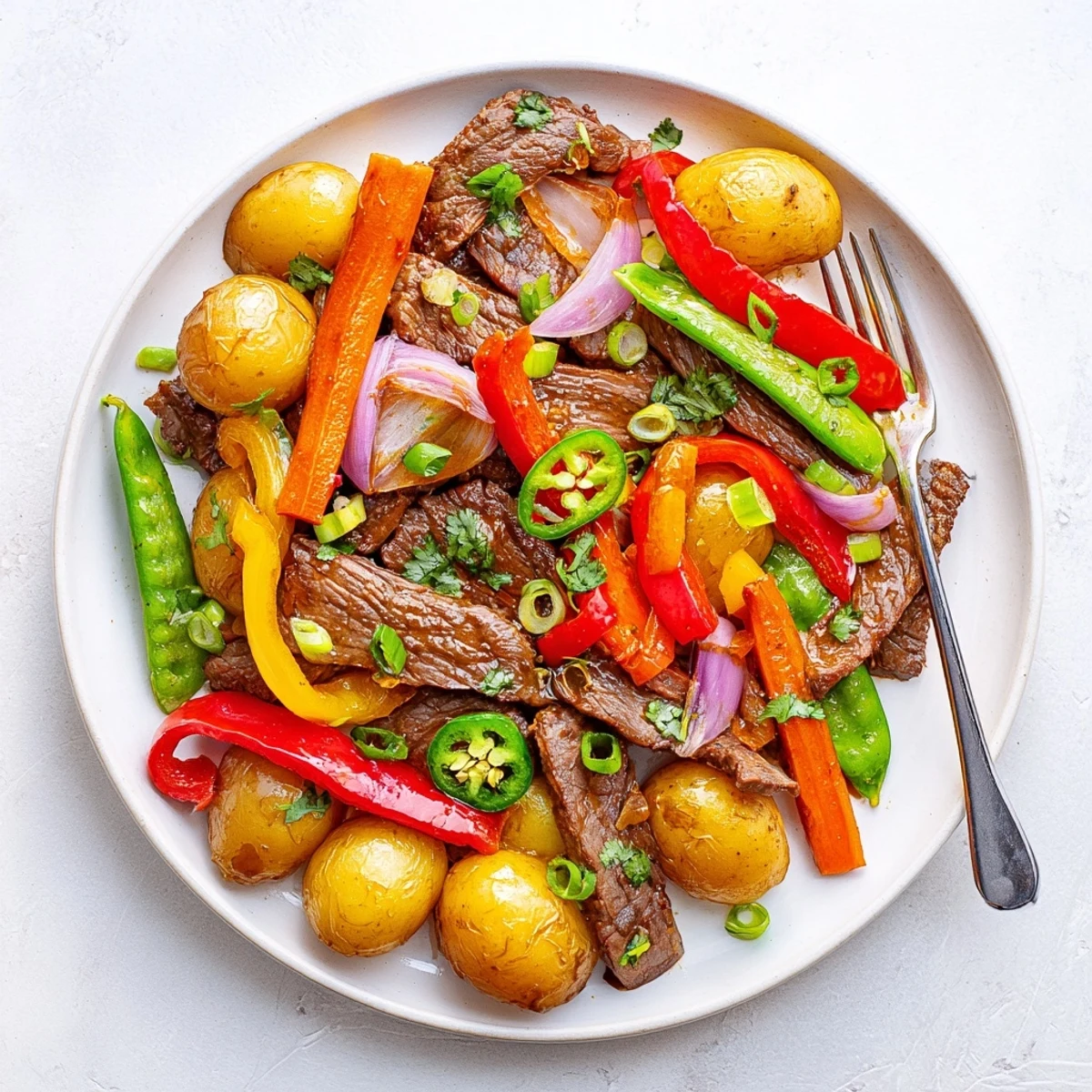 A close-up of Blackstone Cowboy Stir Fry Dinner shows tender beef and crisp veggies glistening.