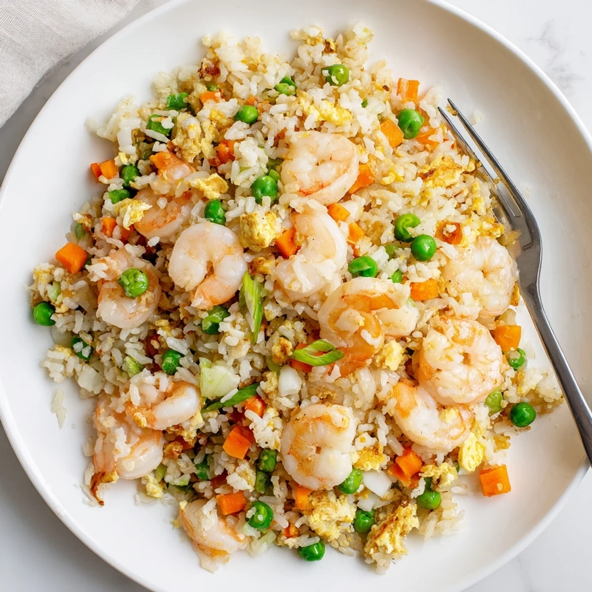 Steaming plate of authentic shrimp fried rice featuring plump shrimp and fluffy jasmine rice
