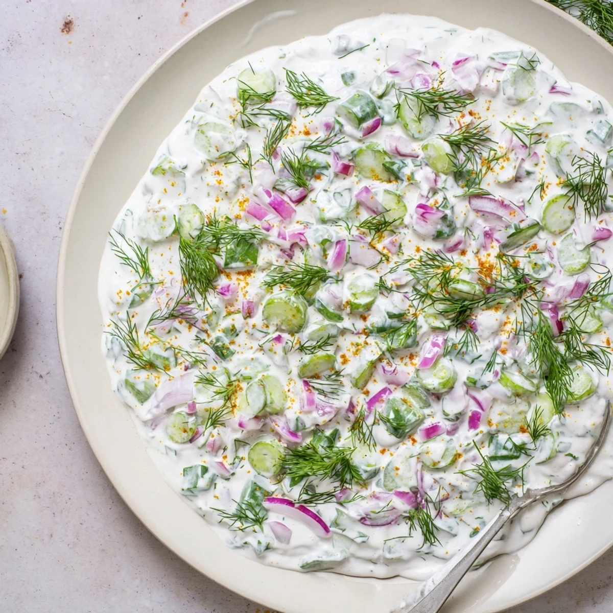 Thick spicy dill pickle burger sauce dolloped onto a wooden board with chopped pickles and red onion garnish