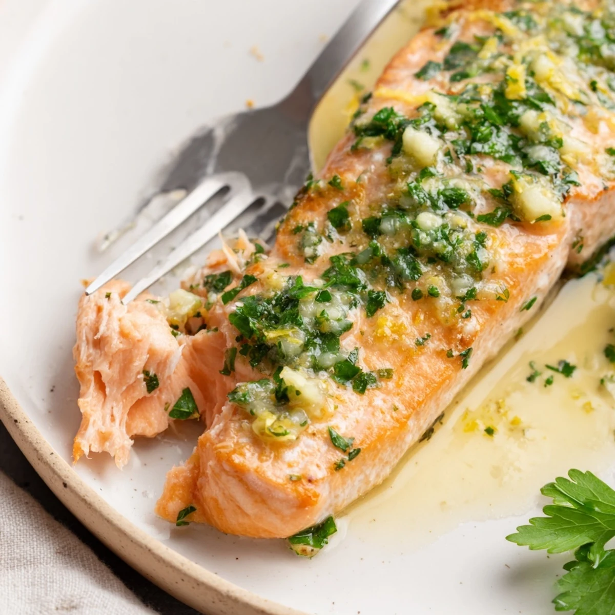 Succulent oven baked salmon glazed with homemade garlic butter and topped with fresh parsley and lemon wedges