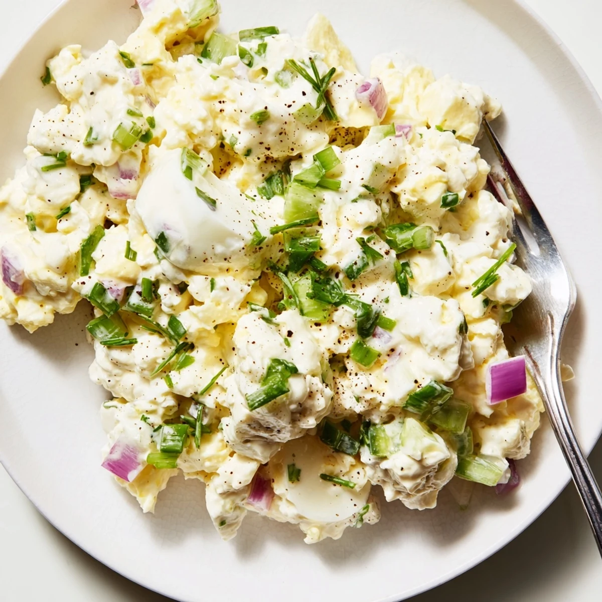 Creamy cottage cheese egg salad with diced vegetables and fresh herbs on plate