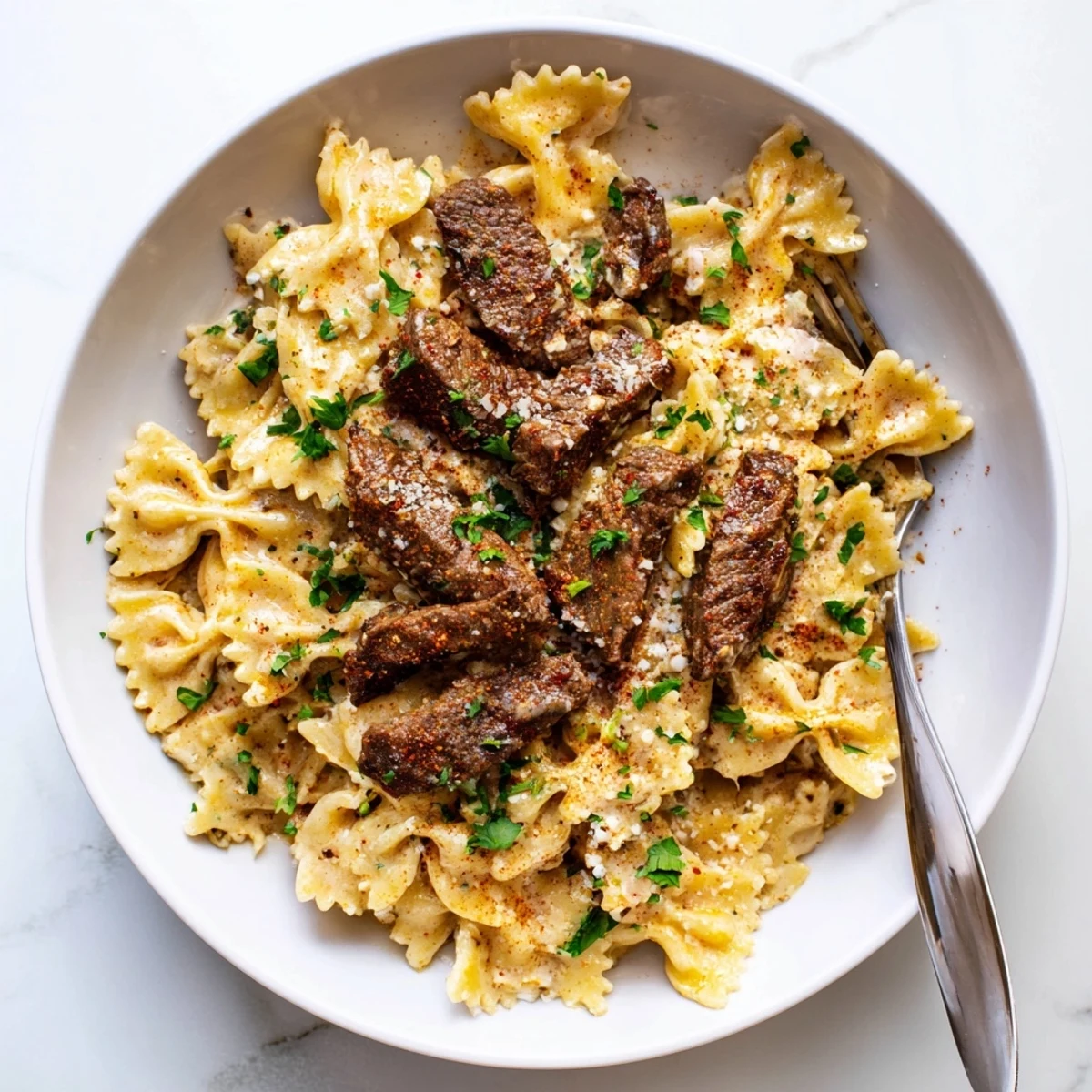 Golden spice-rubbed beef rests on zesty cream cheese Alfredo pasta with parmesan