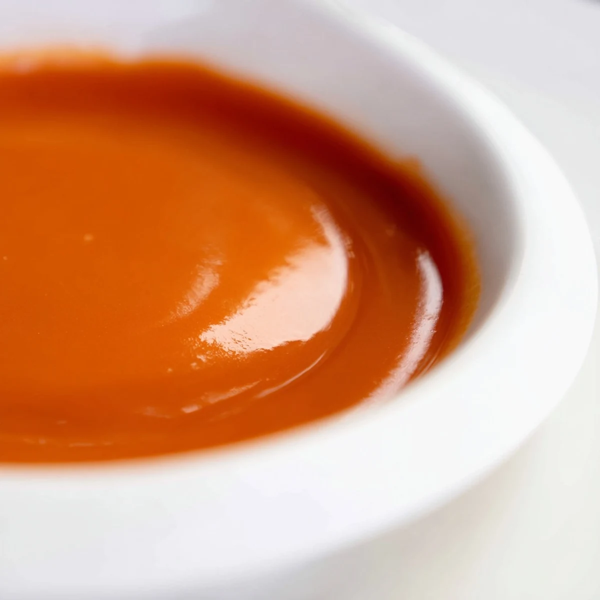 Glossy homemade McDonalds sweet and sour sauce drizzled over crispy golden chicken nuggets