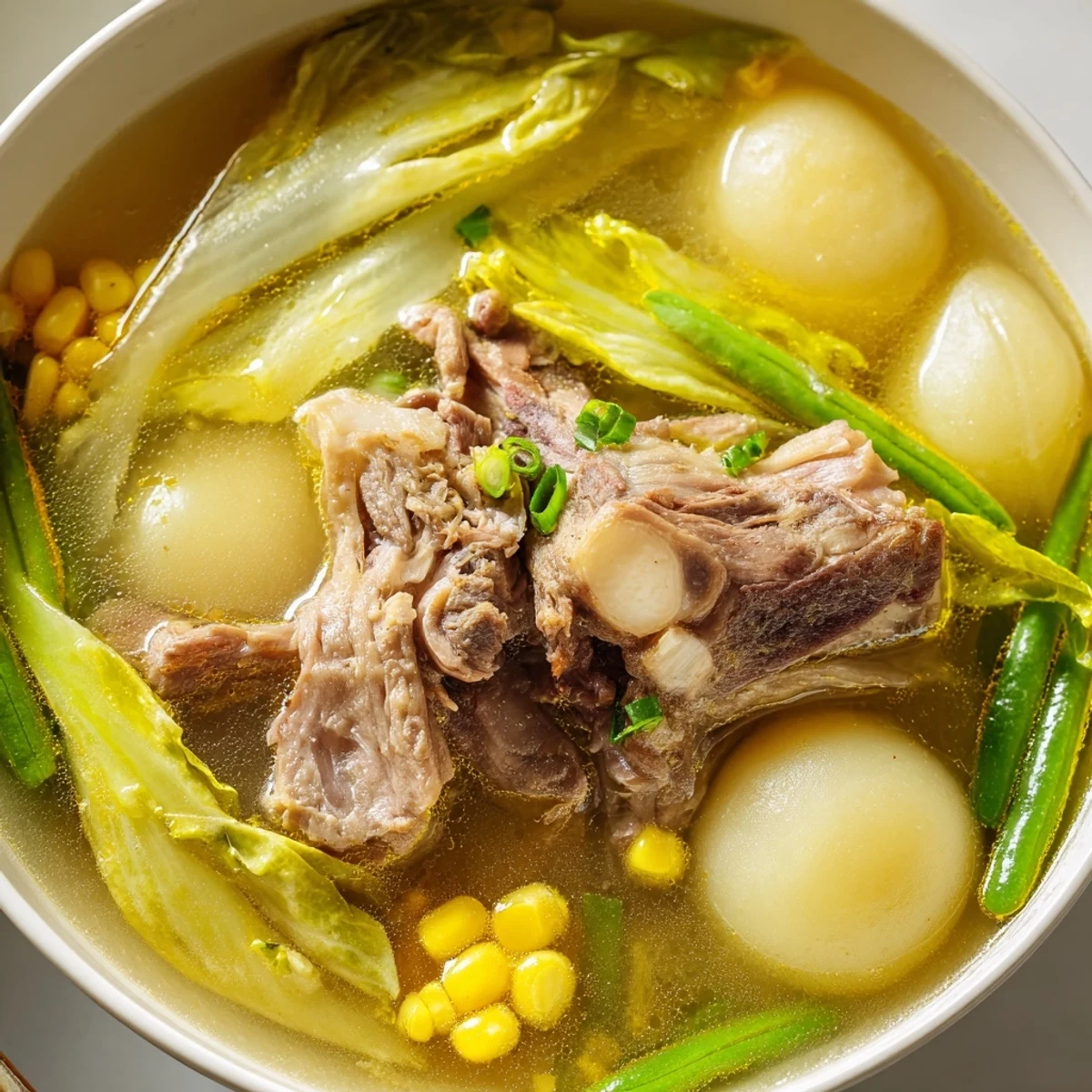 Steaming bowl of Filipino Bulalo with tender beef shank and golden bone marrow