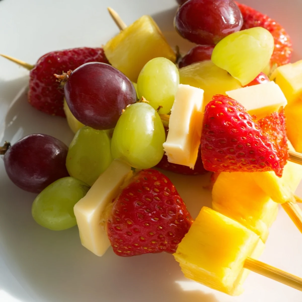 Fruit and cheese kabobs featuring alternating cubes of cheddar mozzarella and fresh seasonal fruits
