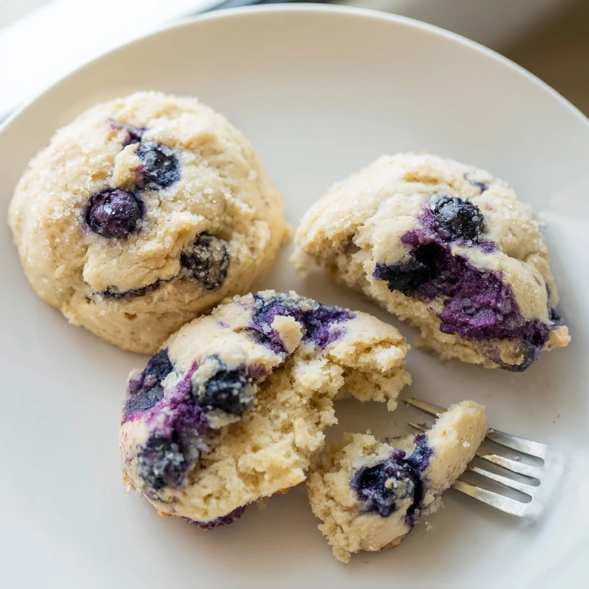 Soft blueberry muffin cookies with golden edges on a parchment-lined baking sheet
