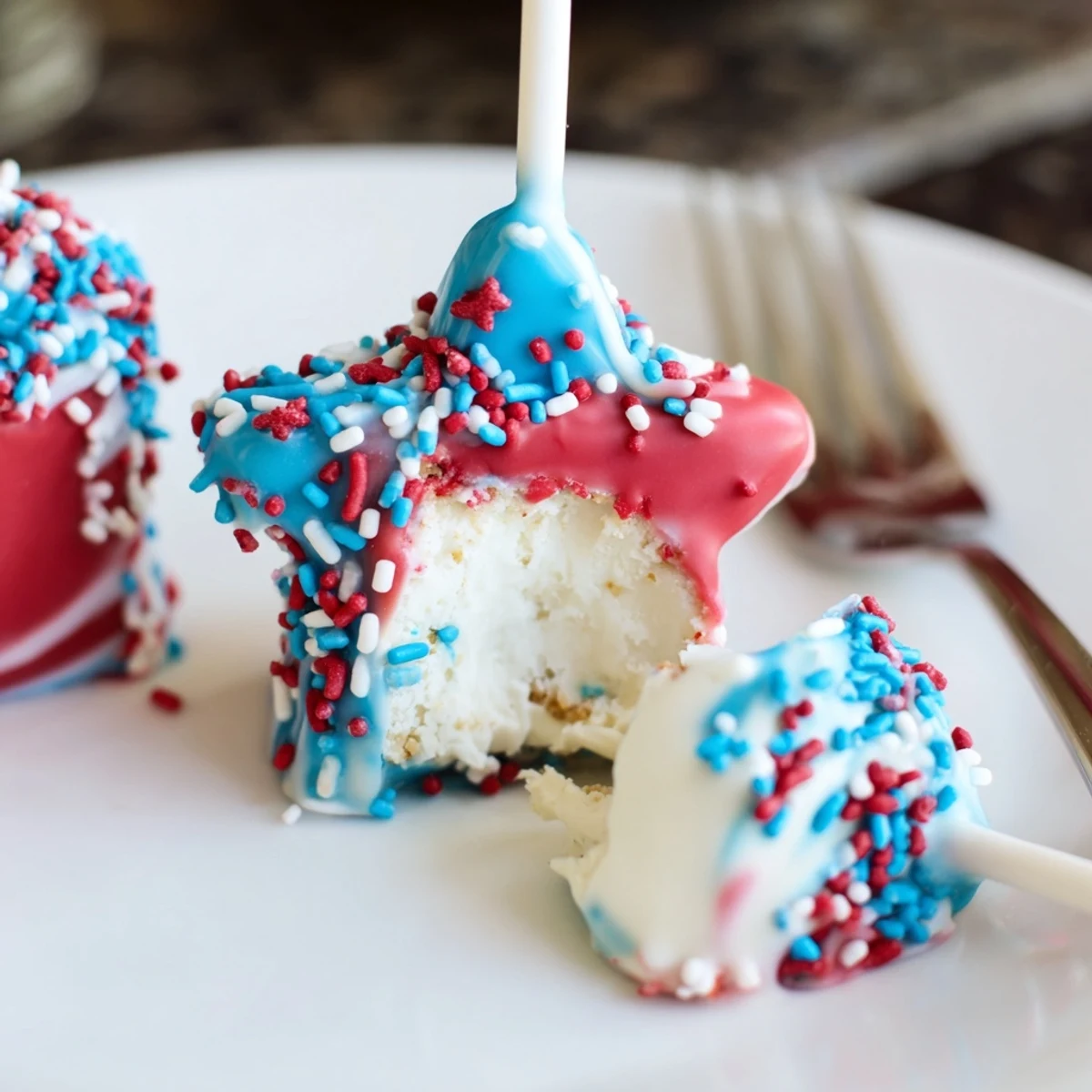 Fourth Of July Star Cheesecake Pops with glossy red, white, and blue coating.