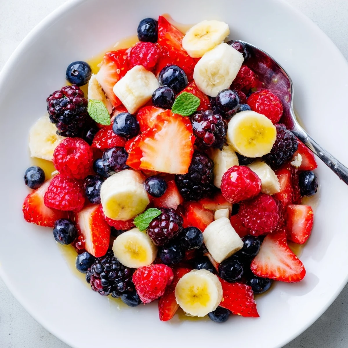 Red White And Blue Fruit Salad glistening with honey-lime dressing, summer picnic centerpiece