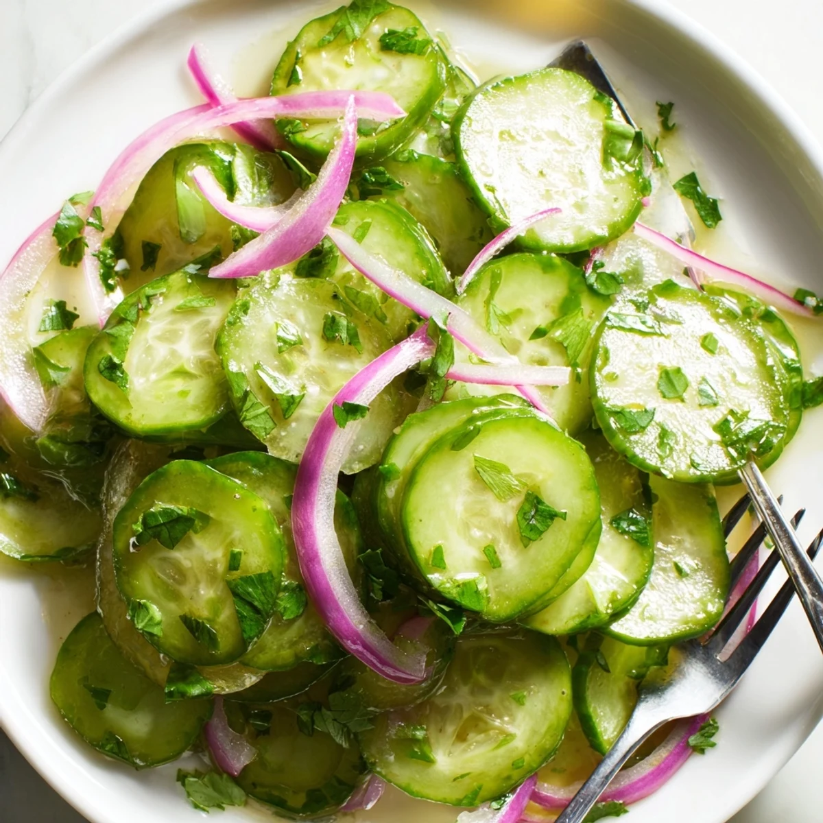 Glowing green cucumber salad tossed with vibrant cilantro in sweet honey lime dressing and sesame seed garnish