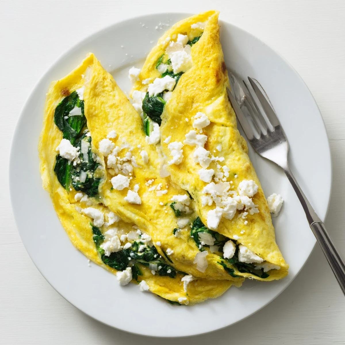 Fluffy Mediterranean spinach feta omelet served on a white ceramic plate