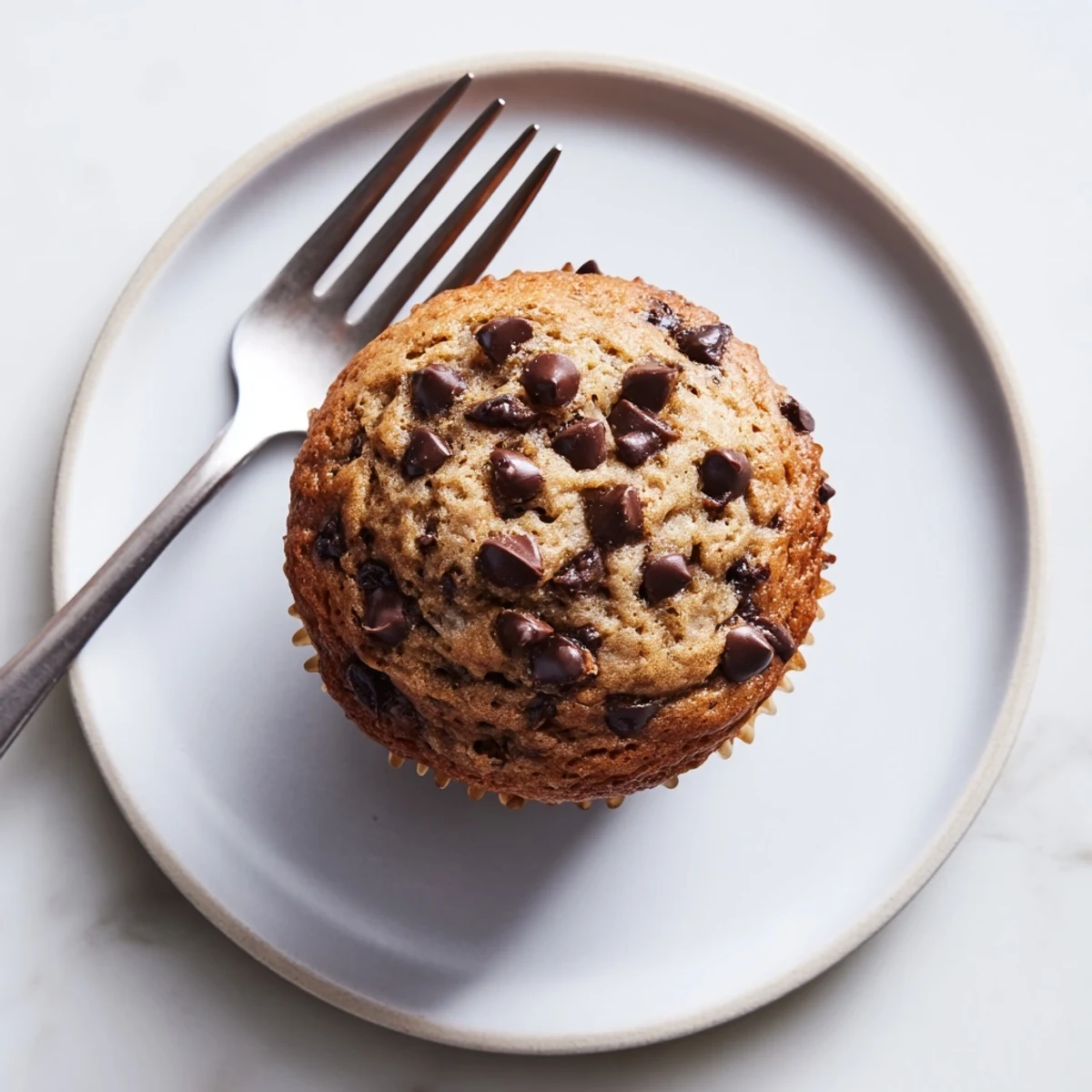Close up of moist banana espresso chocolate chip muffins with visible coffee speckles and chocolate pockets
