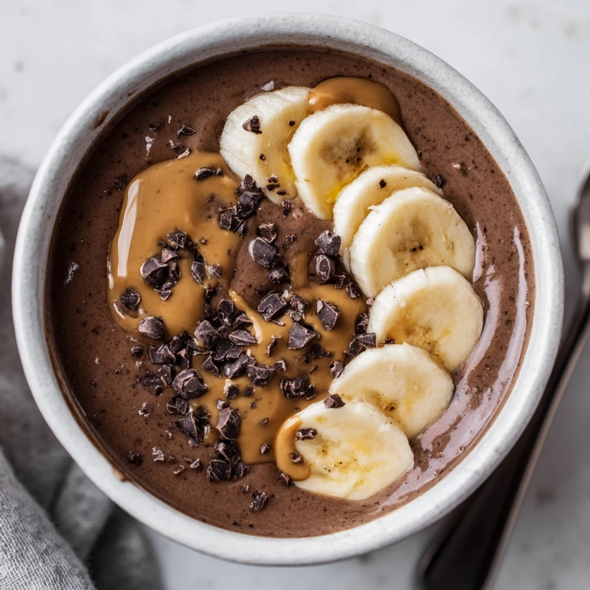 Creamy Chocolate Peanut Butter Banana drink chilled in tall glass with straw