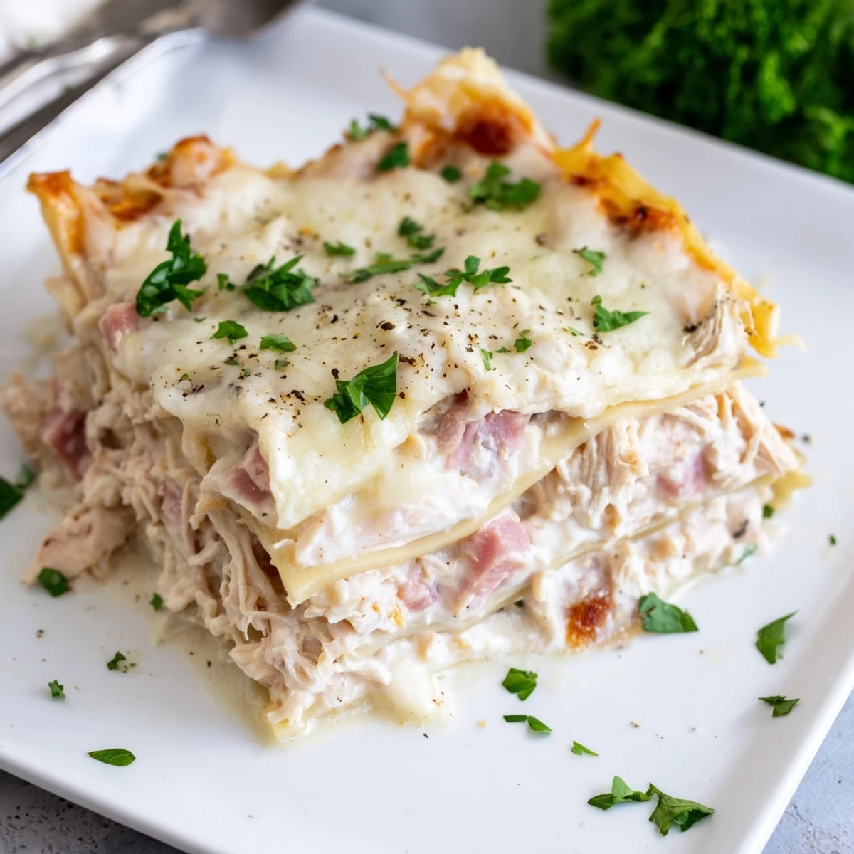 Sliced Chicken Cordon Bleu Lasagna showing tender ham and shredded chicken in rich béchamel