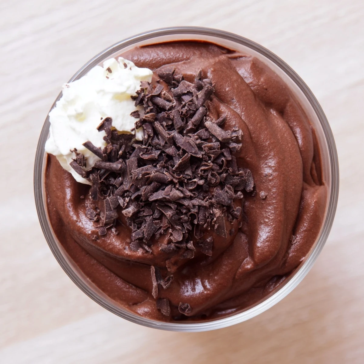 Silky chocolate mousse spooned into dessert cups with a dollop of whipped cream